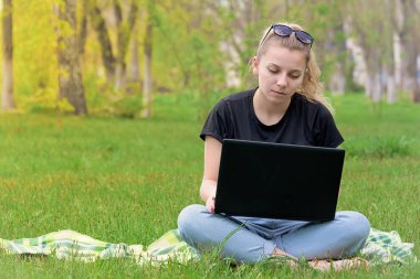 çimlerde oturan laptop ile kız