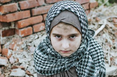 savaşta bir mülteci çocuk, harabeler üzerinde kirli bir yüzü olan Müslüman bir kız, barış ve savaş kavramı, çocuk ağlıyor ve yardım bekliyor.