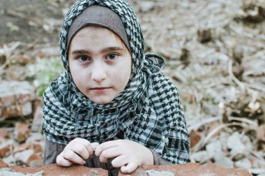 savaşta bir mülteci çocuk, harabeler üzerinde kirli bir yüzü olan Müslüman bir kız, barış ve savaş kavramı, çocuk ağlıyor ve yardım bekliyor.
