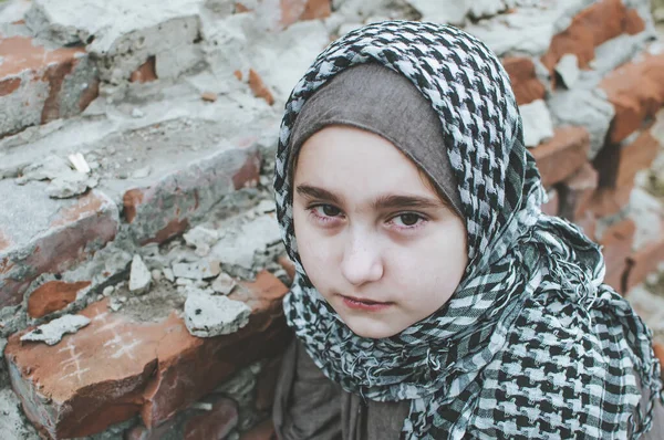 Дитина-біженець у війні, мусульманська дівчина з брудним обличчям на руїнах, поняття миру і війни, дитина плаче і чекає допомоги. — стокове фото