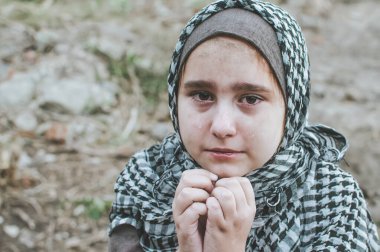 savaşta bir mülteci çocuk, harabeler üzerinde kirli bir yüzü olan Müslüman bir kız, barış ve savaş kavramı, çocuk ağlıyor ve yardım bekliyor.