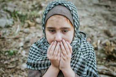 savaşta bir mülteci çocuk, harabeler üzerinde kirli bir yüzü olan Müslüman bir kız, barış ve savaş kavramı, çocuk ağlıyor ve yardım bekliyor.