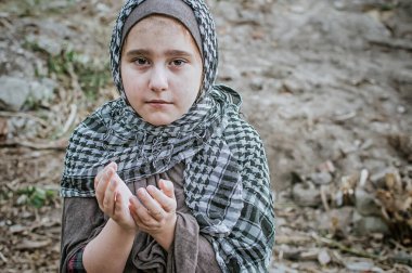 savaşta bir mülteci çocuk, harabeler üzerinde kirli bir yüzü olan Müslüman bir kız, barış ve savaş kavramı, çocuk ağlıyor ve yardım bekliyor.