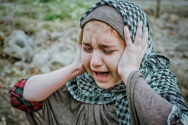 Un enfant réfugié dans la guerre, une fille musulmane avec un visage sale sur les ruines, le concept de paix et de guerre, l'enfant pleure et attend de l'aide . — Photo