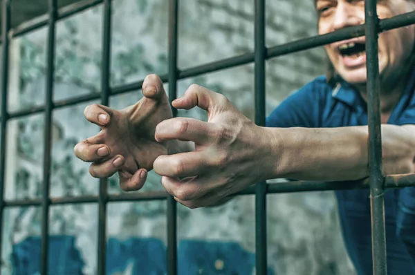 Депресивний чоловік тримає руки у в'язницях. В'язень за злочин. Погані умови. Крик, відчай, біль, голод . — стокове фото