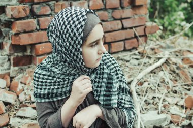 savaşta bir mülteci çocuk, harabeler üzerinde kirli bir yüzü olan Müslüman bir kız, barış ve savaş kavramı, çocuk ağlıyor ve yardım bekliyor.