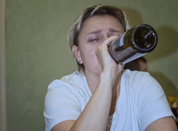 Μια παντρεμένη γυναίκα κλαίει και πίνει αλκοόλ. γυναικεία αλκοολισμός. επιλεκτική εστίαση. κόκκους μεμβράνης. — Φωτογραφία Αρχείου