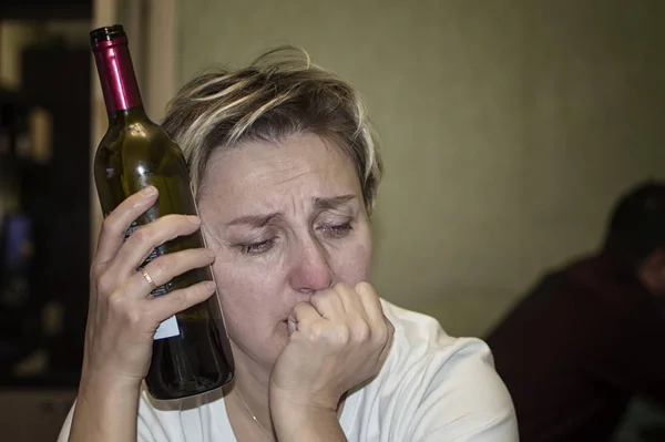 Une femme mariée pleure et boit de l'alcool. alcoolisme féminin.foyer sélectif. grain de film . — Photo