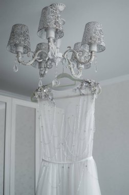 Gelinin gelinliği avizeye asılı. Düğün. Seçici odaklanma. film tahılı.