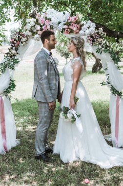 Düğün törenindeki gelin ve damat düğün kemerinde. Seçici odaklanma. film tahılı.