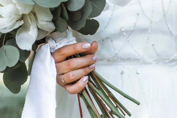 wedding bouquet of white peonies in the hand of the bride on the wedding day. selective focus. film grain