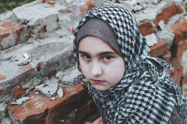 savaşta bir mülteci çocuk, harabeler üzerinde kirli bir yüzü olan Müslüman bir kız, barış ve savaş kavramı, çocuk ağlıyor ve yardım bekliyor.
