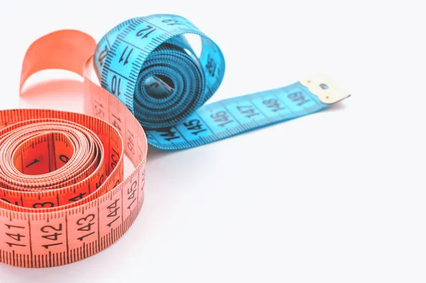 Centimeter ribbon pink and blue on a white background. The concept of weight loss and a healthy lifestyle. Stock Photo