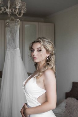 Gelinliğinin arka planında gelinlik var. Tören için hazırlık. Düğün günü. Seçici odaklanma. film tahılı.