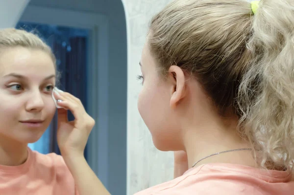 Söt vacker flicka tar bort makeup med hjälp av bomullspads. närbild. — Stockfoto