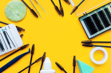 Şablon. Sarı arkaplanda kirpik uzantısı ve yazmak için bir yer için araçlar.