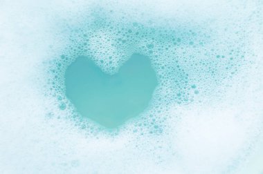 Texture soap foam with a place of water in the shape of a heart. The concept of cleanliness and hygiene.