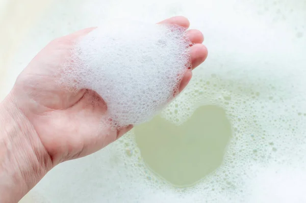 Tvål suger på en persons hand på en bakgrund av tvål suger. Begreppet renlighet och hygien. — Stockfoto