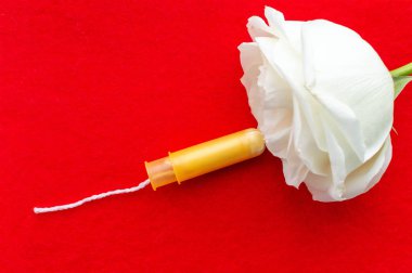 women's tampons with a rose flower on a blue background. The concept of women's health.