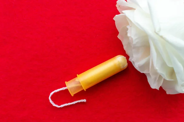 Tampones de mujer con una flor de rosa sobre un fondo azul. El concepto de salud de la mujer . —  Fotos de Stock