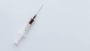 Beyaz arka planda ilaç olan bir şırınga. Virüs aşısı ve sağlık koruma kavramı.