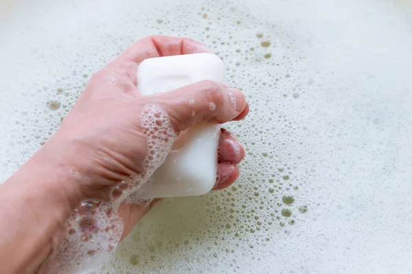 Кусок Белого Мыла Руке Мужчины Фоне Мыльной Посуды Концепция Гигиены — стоковое фото