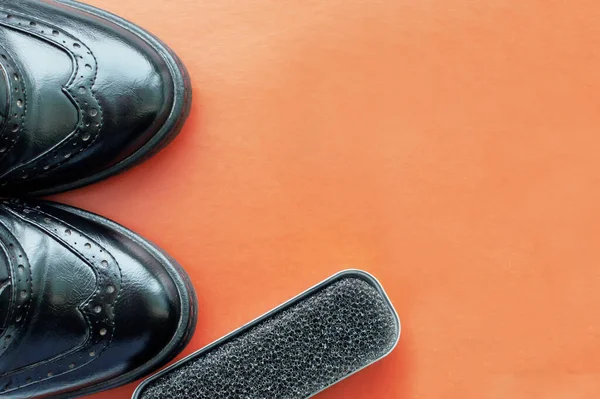 Uma Esponja Sapato Lado Sapatos Couro Preto Polido Fundo Laranja — Fotografia de Stock