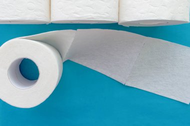 Mavi arka planda beyaz tuvalet kağıdı ruloları. Kapatın. Yukarıdan görünüşü.