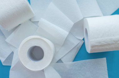 Mavi arka planda beyaz tuvalet kağıdı ruloları. Kapatın. Yukarıdan görünüşü.