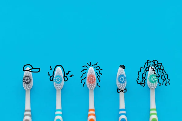 Bunte Zahnbürsten Auf Blauem Hintergrund Form Von Comicfiguren Der Blick — Stockfoto