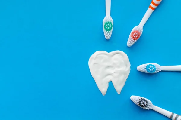 Mehrfarbige Zahnbürsten Auf Blauem Hintergrund Mit Einem Mit Zahnpasta Gezeichneten — Stockfoto