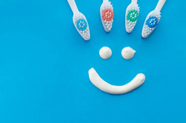 Multicolored Toothbrushes Blue Background Smile Painted Toothpaste View Top Concept — Stock Photo, Image