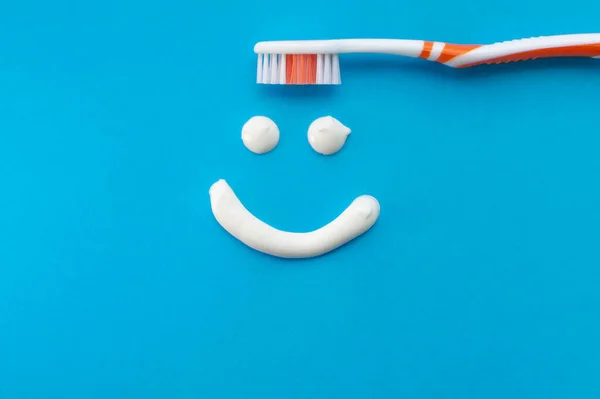 Escova Dentes Laranja Fundo Azul Com Sorriso Pintado Com Pasta — Fotografia de Stock