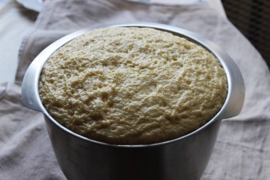 Büyük bir cam kasede maya hamuru. Ev yapımı kek. Karantina döneminde ödev kavramı. Kapat..