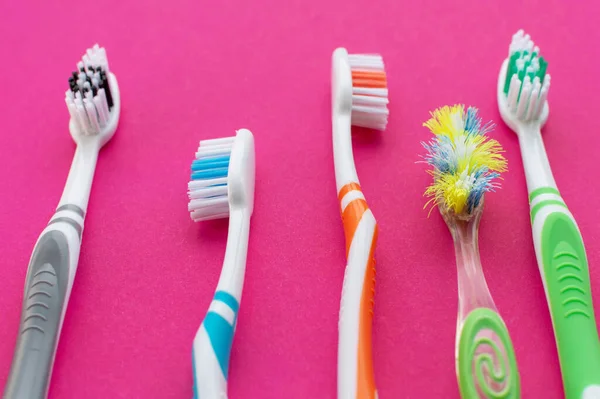 Bunte Neue Zahnbürsten Und Eine Alte Zahnbürste Auf Rosa Hintergrund — Stockfoto