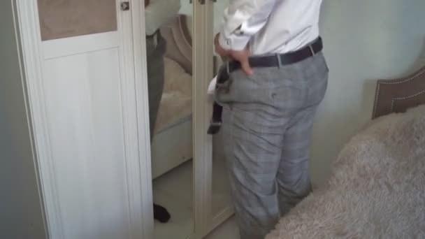 un homme s'habille avant le travail, le marié s'habille avant le mariage, regarde dans le miroir 