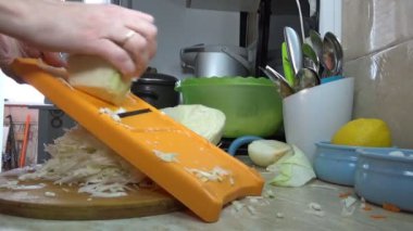 Kız salata ya da sebze güveci için lahana öğütür.