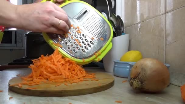 女の子は家のキッチンでサラダや野菜のシチューのためにニンジンをカット — ストック動画