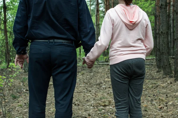 男は森の中で１０代の少女の手を握っている 誘拐と児童売買の概念 閉じろ — ストック写真