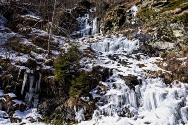Kışın kar soğuk sıcaklık, buz şelaleler yamaçları boyunca şekillendirme sırasında eriyor gibi dağ yamaçları buz ve buz sarkıtları kaplı