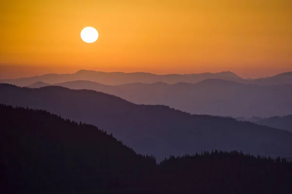 Tepeler ve dağlar Romanya'da Bucovina bölgesinin üzerinden günbatımı