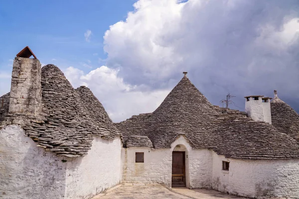 Onların belirli konik taş shingle çatı İtalya Alberobello şehrin güzel beyaz evler