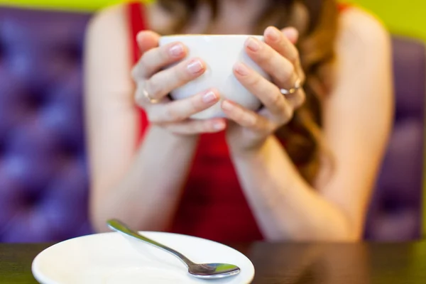 Teenager girl is drinking coffee in a cafe — Stock Photo, Image
