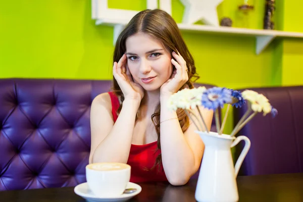 Teenager girl is drinking coffee in a cafe — Stock Photo, Image