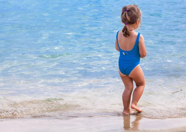 Adorable niña de pie en la playa tropical — Foto de Stock