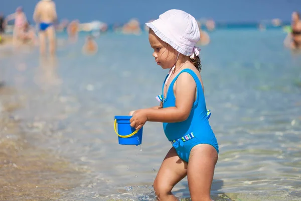 Enfant fille joue sur la plage de sable près de la mer bleue — Photo