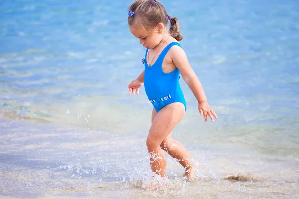 Adorável menina de pé na praia tropical — Fotografia de Stock