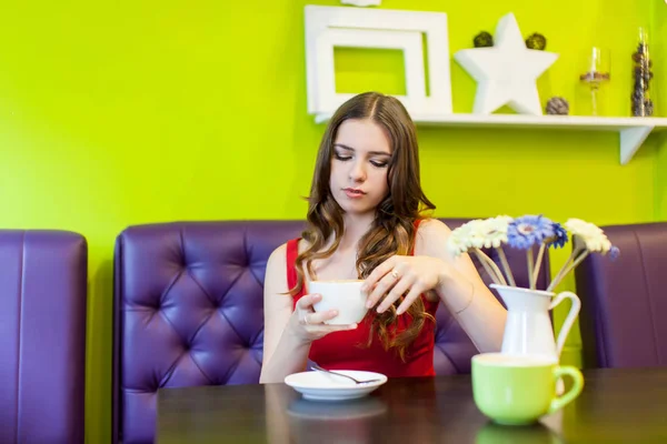 Une jeune belle femme boit du café dans un café — Photo