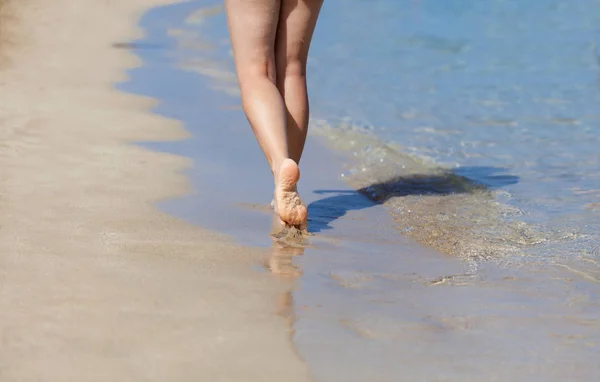 双腿的女人走在沙滩上 — 图库照片