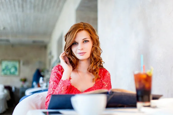 Μια νεαρή όμορφη γυναίκα πίνει καφέ σε μια καφετέρια — Φωτογραφία Αρχείου